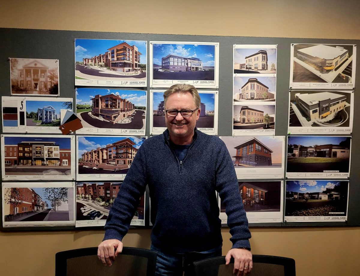 Loveless Porter CEO Sean Porter poses with renderings of architectural projects through Washington DC Virginia and Maryland